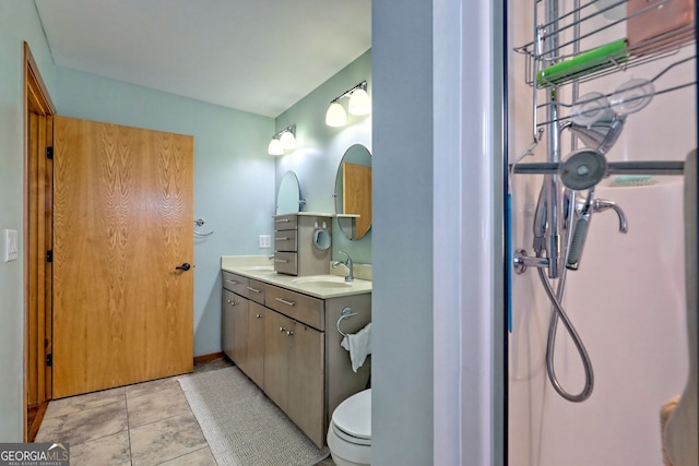 full bathroom featuring toilet, a sink, baseboards, tile patterned floors, and double vanity