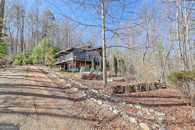 view of property exterior featuring a view of trees and a wooden deck