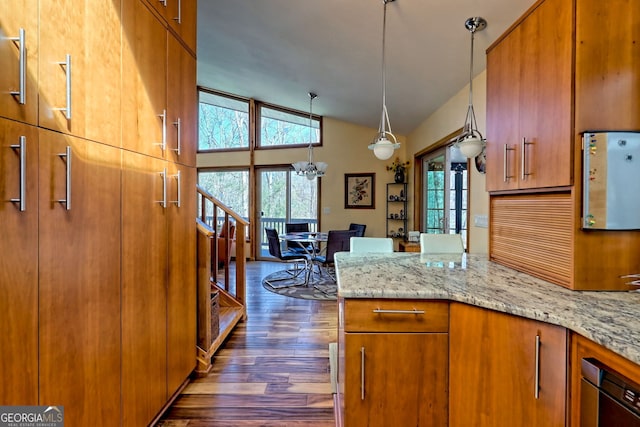 kitchen featuring vaulted ceiling, plenty of natural light, and brown cabinets