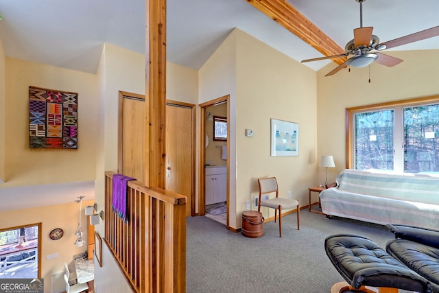 carpeted living area featuring vaulted ceiling with beams and a ceiling fan