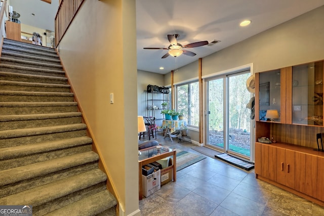 staircase featuring baseboards, visible vents, a ceiling fan, and recessed lighting