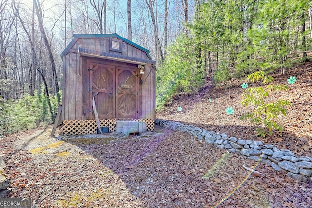 view of shed with a wooded view