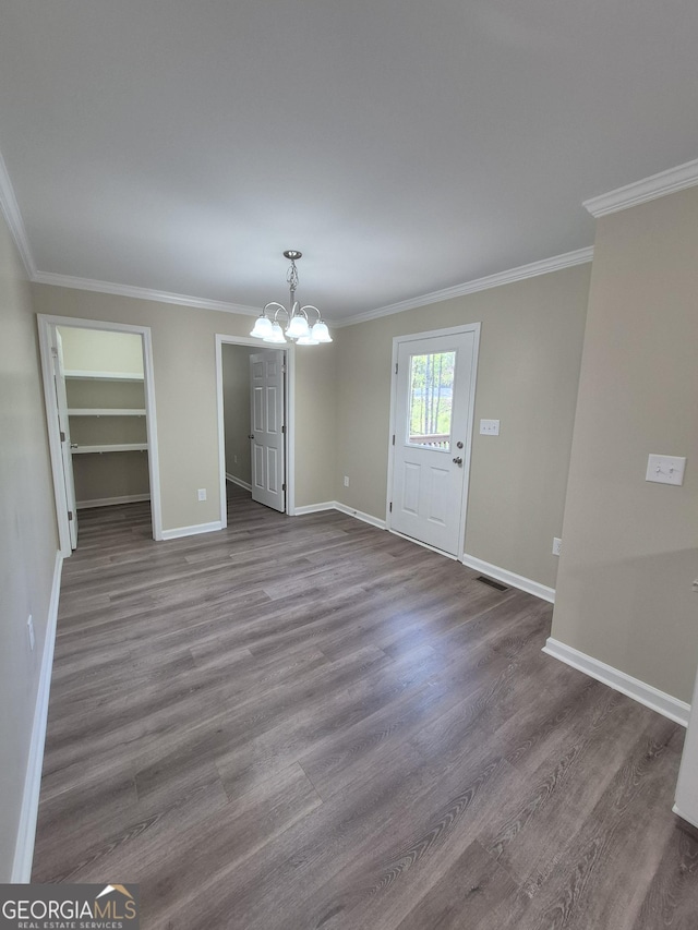 unfurnished dining area with visible vents, baseboards, a chandelier, and wood finished floors