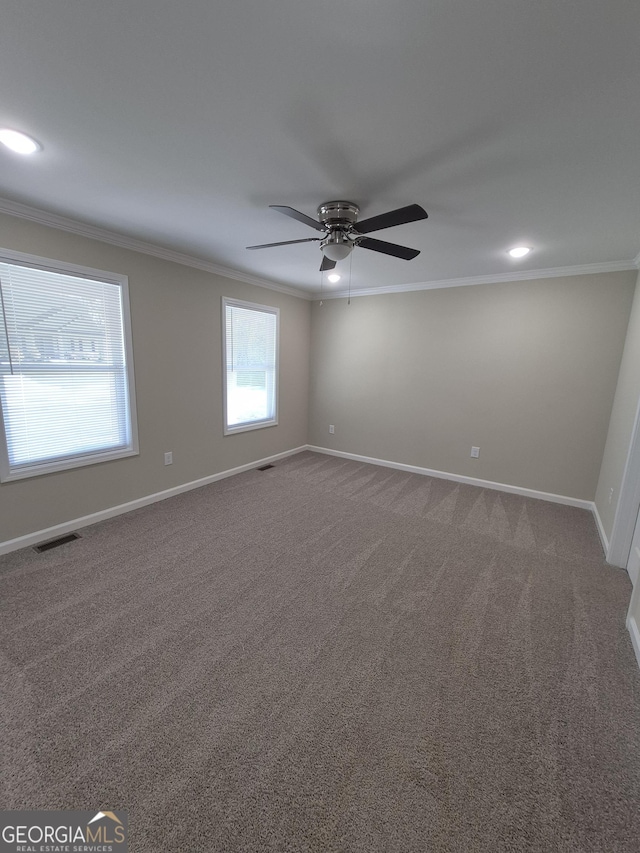 unfurnished room with visible vents, baseboards, and ornamental molding