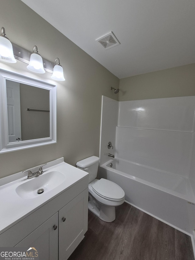 full bathroom with vanity, shower / bath combination, toilet, visible vents, and wood finished floors
