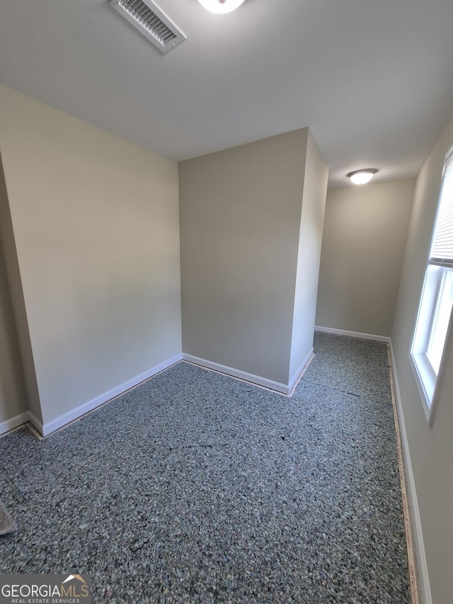 spare room featuring baseboards and visible vents