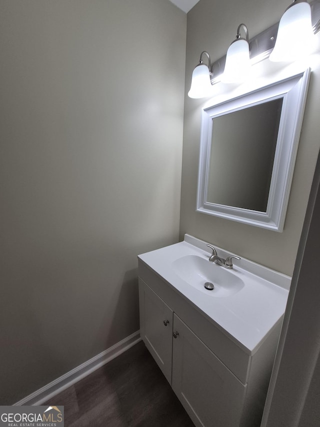 bathroom with baseboards, vanity, and wood finished floors