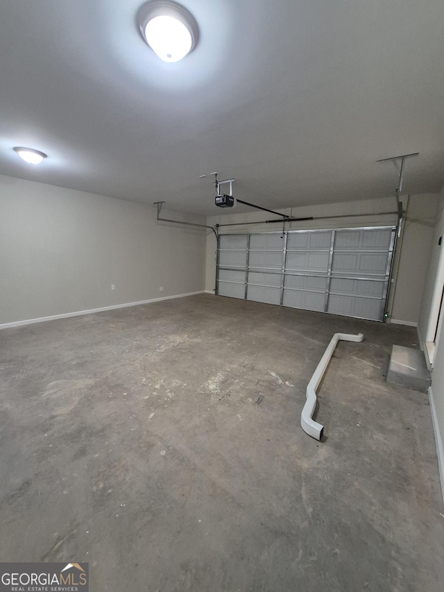 garage with a garage door opener and baseboards
