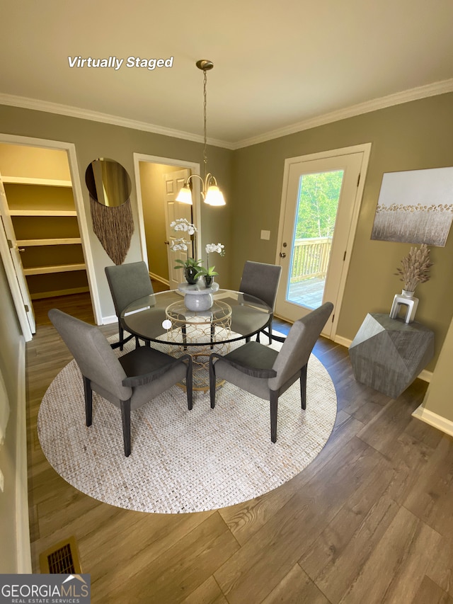 dining area featuring baseboards, crown molding, and wood finished floors
