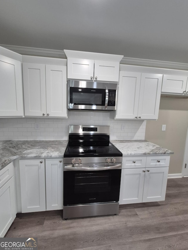 kitchen featuring stainless steel appliances, white cabinetry, and wood finished floors