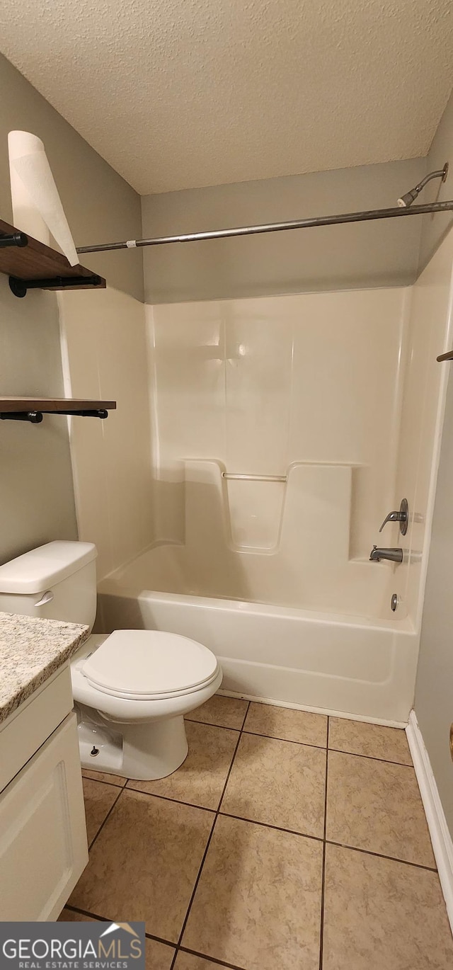 full bathroom with vanity, tile patterned floors, toilet, and a textured ceiling