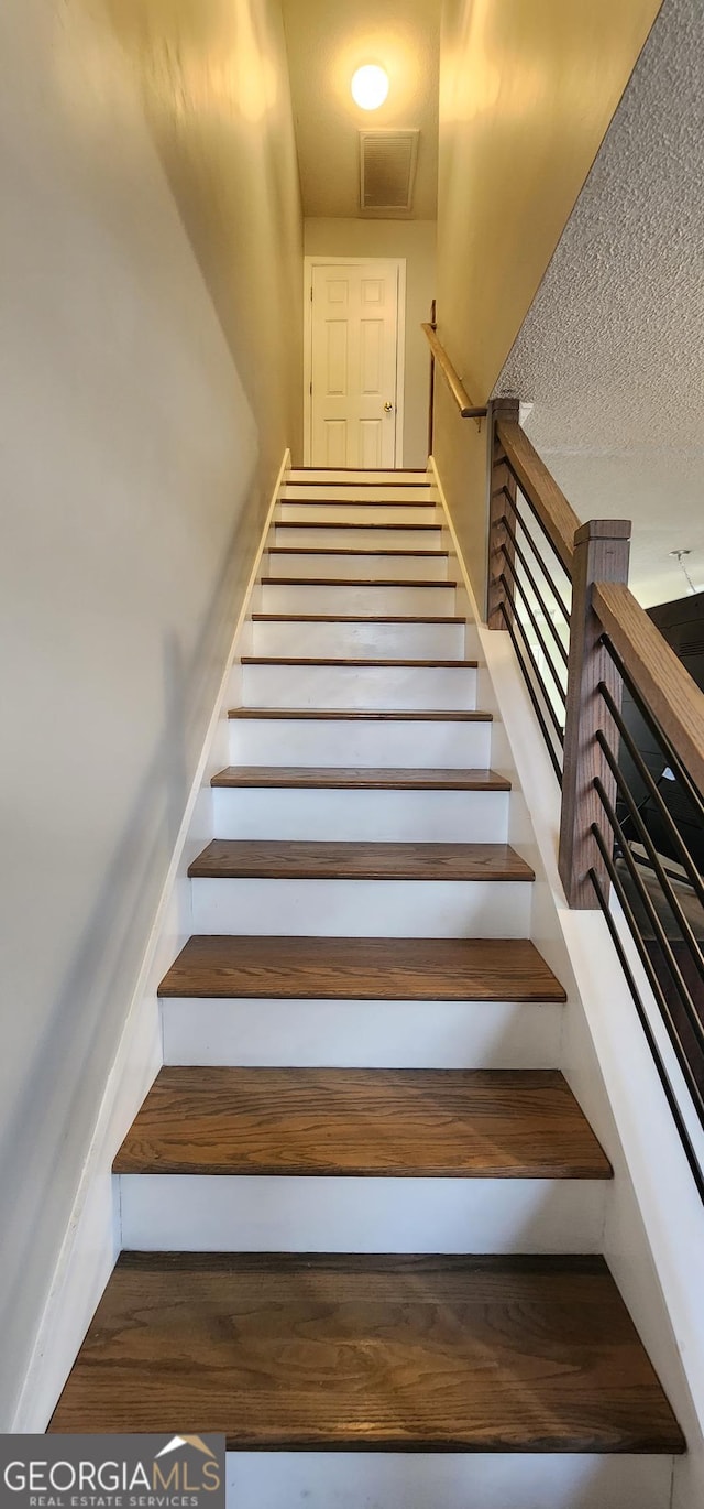 stairway with a textured ceiling