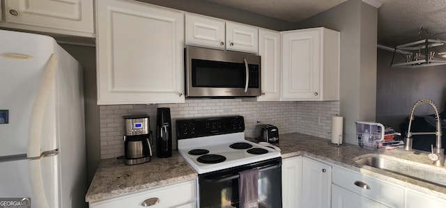 kitchen featuring white fridge, sink, white cabinets, and electric stove