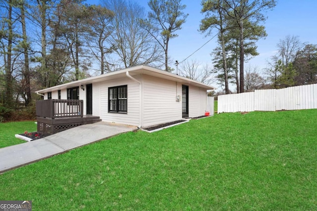 view of property exterior with a wooden deck and a lawn