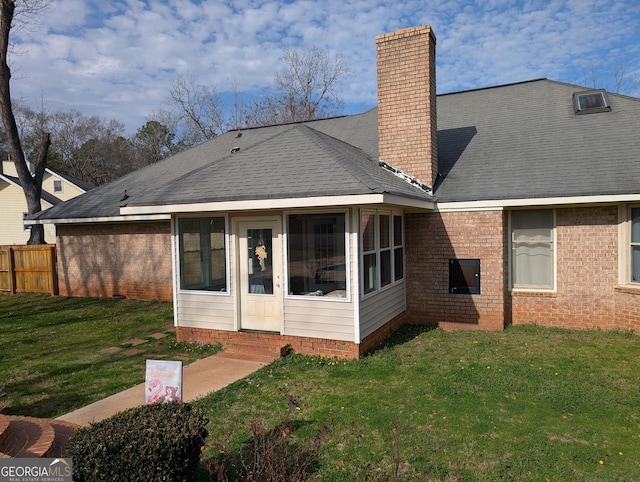 rear view of property featuring a yard