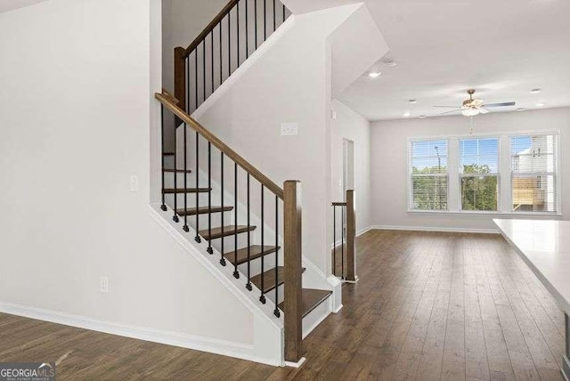 stairway with ceiling fan and hardwood / wood-style floors