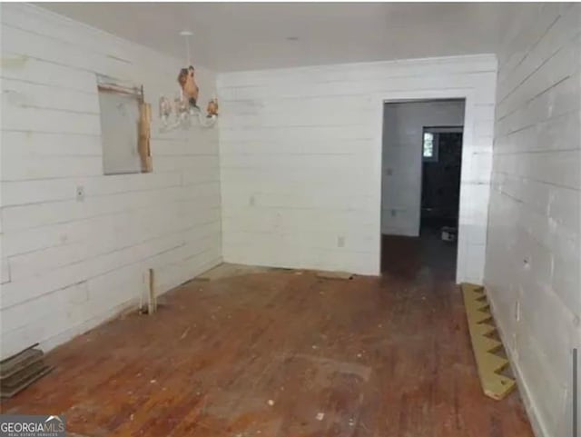 empty room with dark wood-type flooring and electric panel