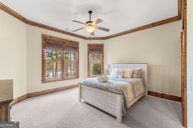 carpeted bedroom featuring crown molding and ceiling fan