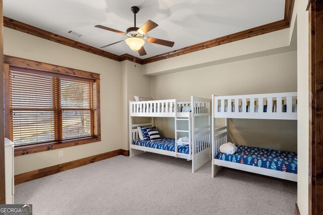 bedroom with ornamental molding, ceiling fan, and carpet flooring