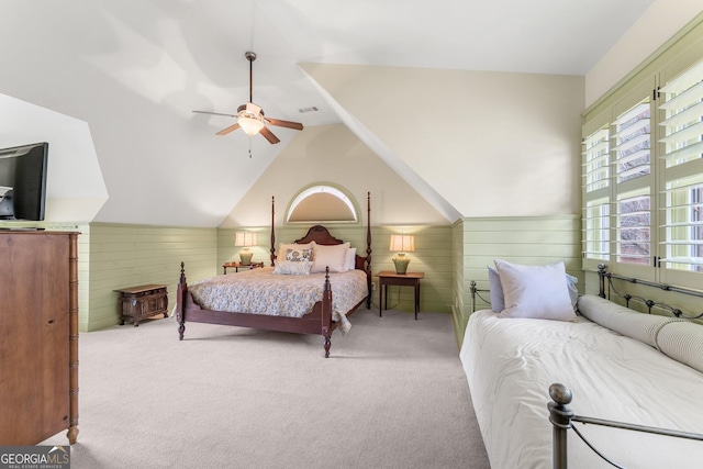 bedroom featuring vaulted ceiling, light carpet, ceiling fan, and wood walls