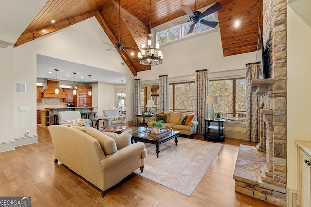 living room with light hardwood / wood-style flooring, wood ceiling, a wealth of natural light, and ceiling fan with notable chandelier