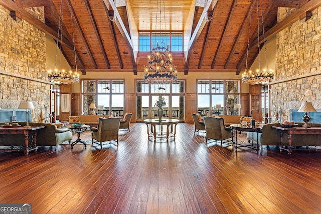 living room with an inviting chandelier, high vaulted ceiling, hardwood / wood-style floors, and a wealth of natural light