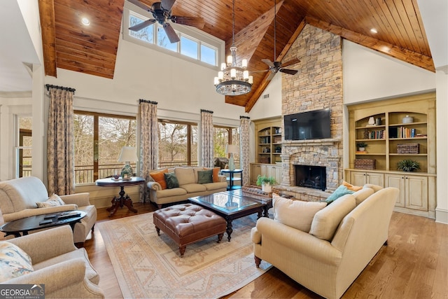 living room featuring wood ceiling, a healthy amount of sunlight, a stone fireplace, and light hardwood / wood-style floors