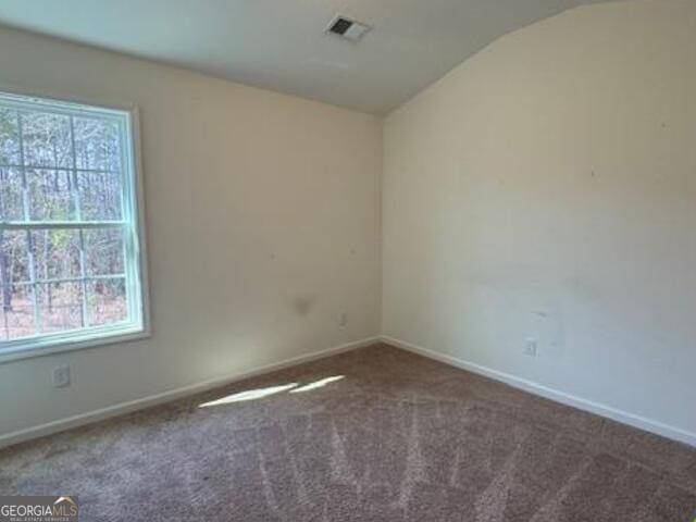 carpeted spare room featuring lofted ceiling and a healthy amount of sunlight