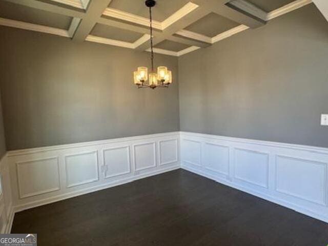 empty room featuring beam ceiling, dark wood-type flooring, an inviting chandelier, and coffered ceiling