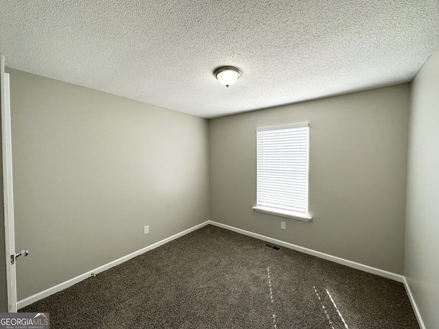 1202 Grove Trail Pass, Douglasville, GA 30134 - spare room featuring dark colored carpet and a textured ceiling