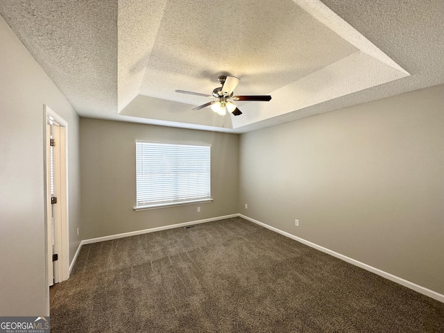 1202 Grove Trail Pass, Douglasville, GA 30134 - unfurnished room with a raised ceiling, a textured ceiling, ceiling fan, and dark carpet