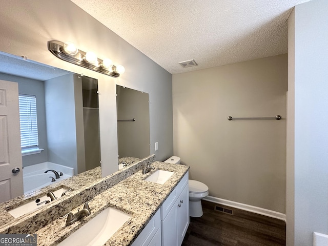 1202 Grove Trail Pass, Douglasville, GA 30134 - full bathroom featuring wood finished floors, double vanity, a garden tub, a textured ceiling, and a shower