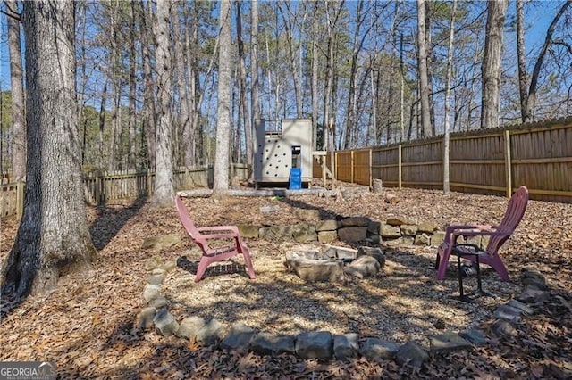 view of yard with a fire pit and a fenced backyard