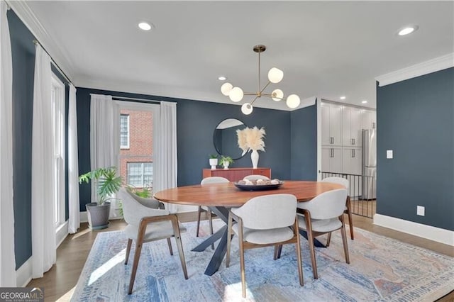 dining space featuring light wood-style flooring, recessed lighting, a notable chandelier, baseboards, and ornamental molding