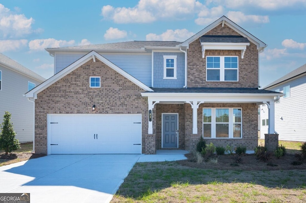 craftsman house featuring a garage, brick siding, a porch, and driveway