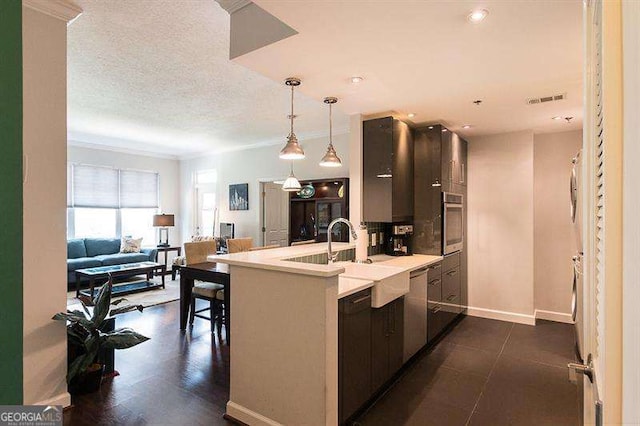 kitchen featuring a textured ceiling, visible vents, open floor plan, light countertops, and appliances with stainless steel finishes