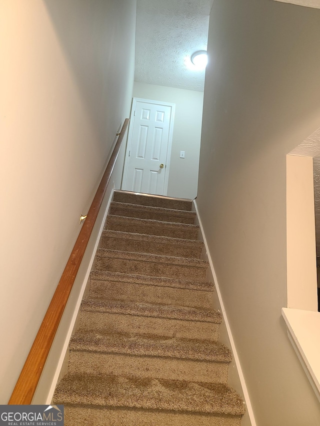 stairway with a textured ceiling