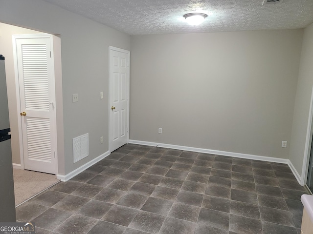 spare room with a textured ceiling