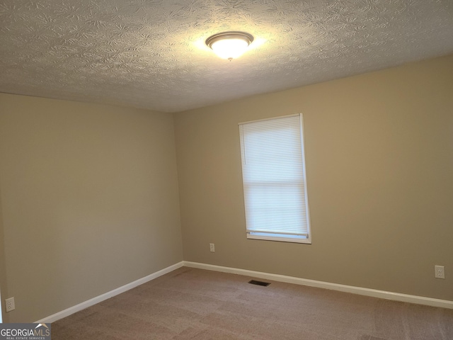 spare room with carpet floors and a textured ceiling