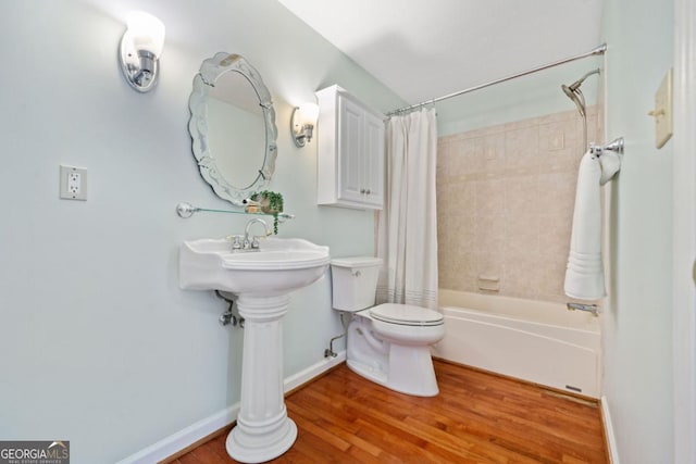 bathroom featuring wood-type flooring, shower / bath combination with curtain, and toilet