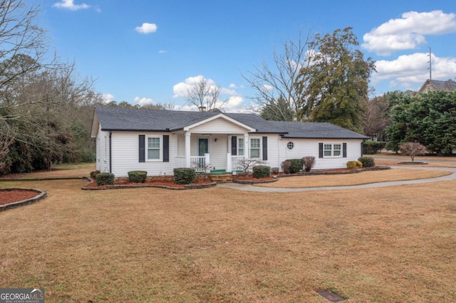 ranch-style home featuring covered porch and a front lawn