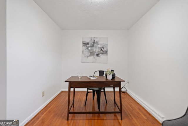 office area with hardwood / wood-style floors and a textured ceiling