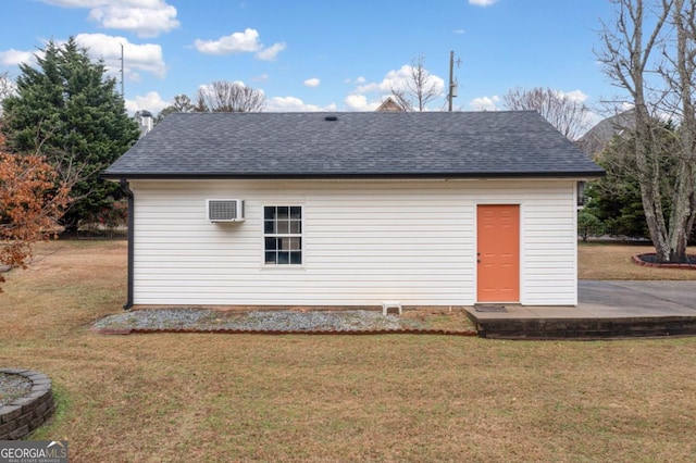 view of outdoor structure with a yard and a wall unit AC