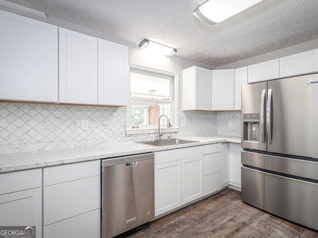 kitchen with sink, dark hardwood / wood-style floors, stainless steel appliances, decorative backsplash, and white cabinets