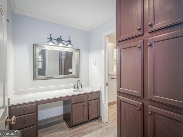 bathroom with vanity, hardwood / wood-style floors, and crown molding