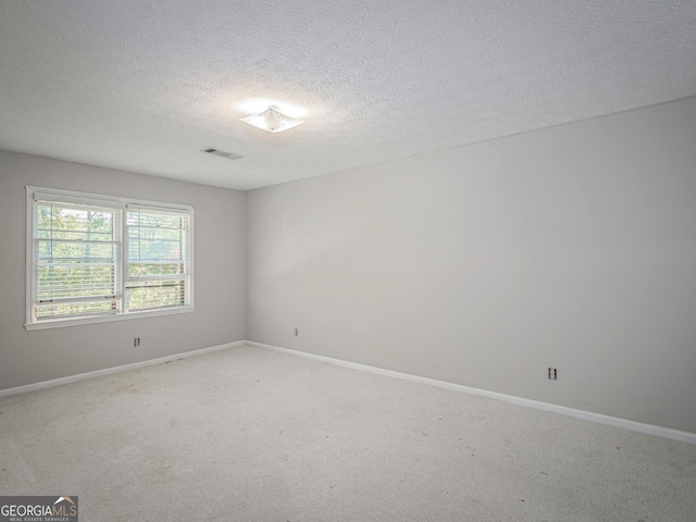 carpeted empty room with a textured ceiling