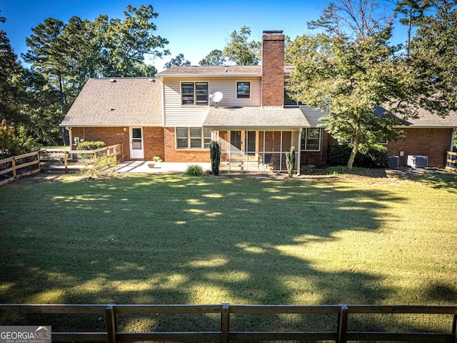 rear view of property with central AC, a lawn, and a sunroom