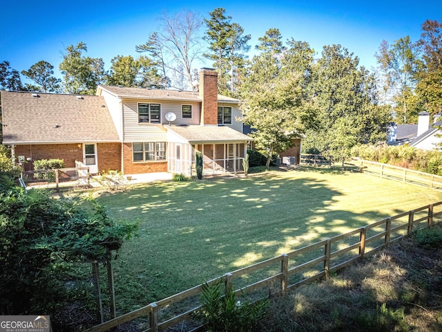 back of property featuring a lawn and a sunroom