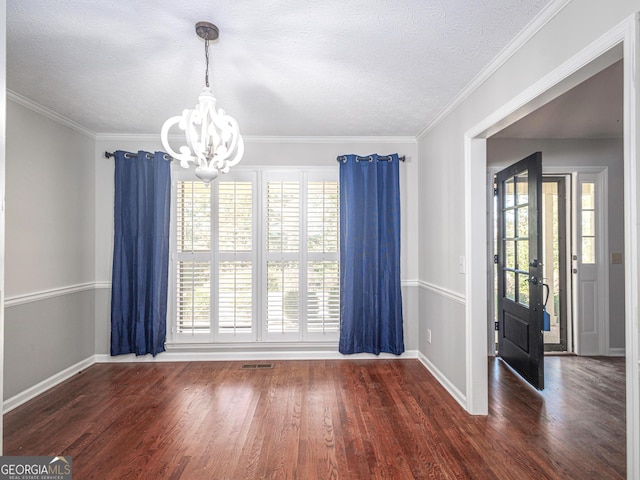 unfurnished dining area featuring an inviting chandelier, dark wood-type flooring, and ornamental molding