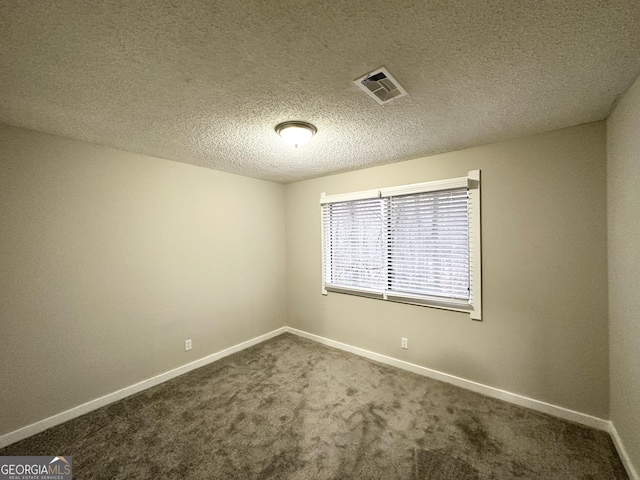 carpeted empty room featuring a textured ceiling